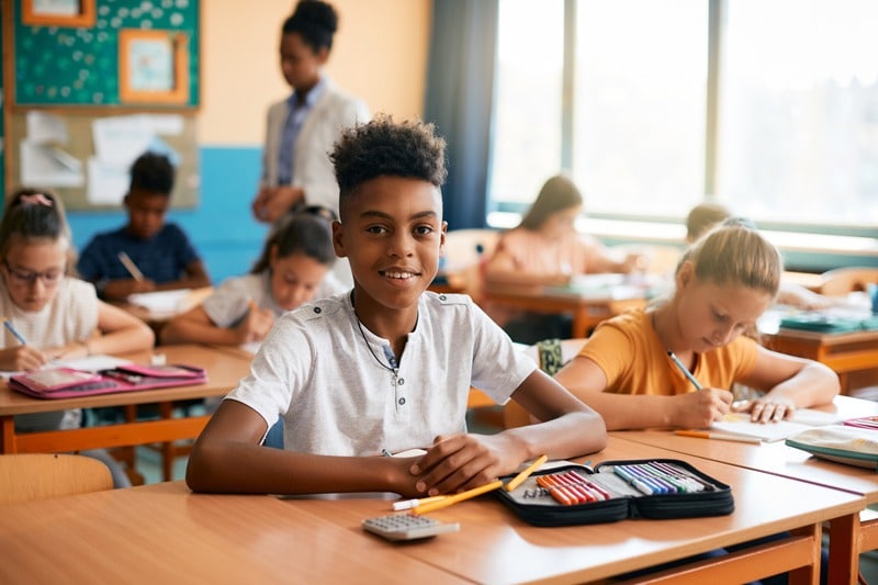 students working in classroom boy smiling