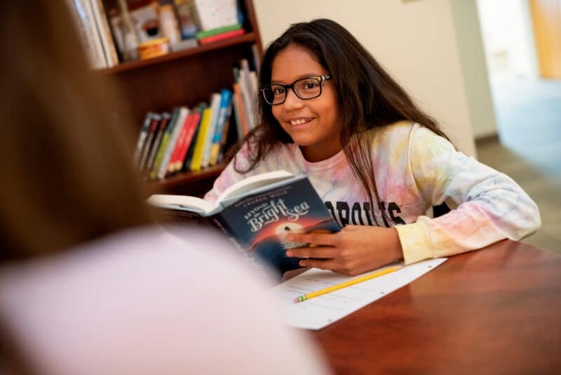 smiling student reading a book