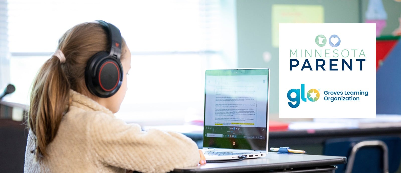 girl wearing headphones at desk looking at screen